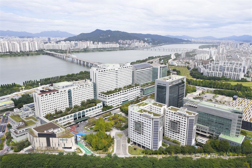 首爾峨山醫院的外觀：數棟相連的高層醫療大樓，前方是車道與綠地
